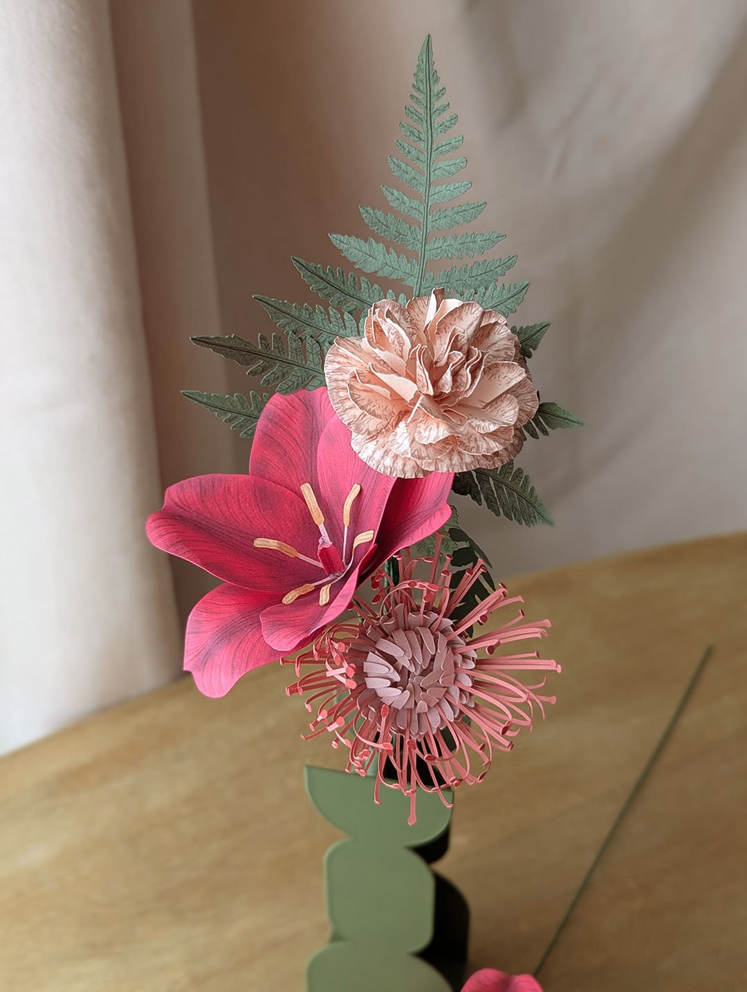 Gros plan sur une tulipe ouverte fuchsia et un oeillet rose pâle en papier fait main