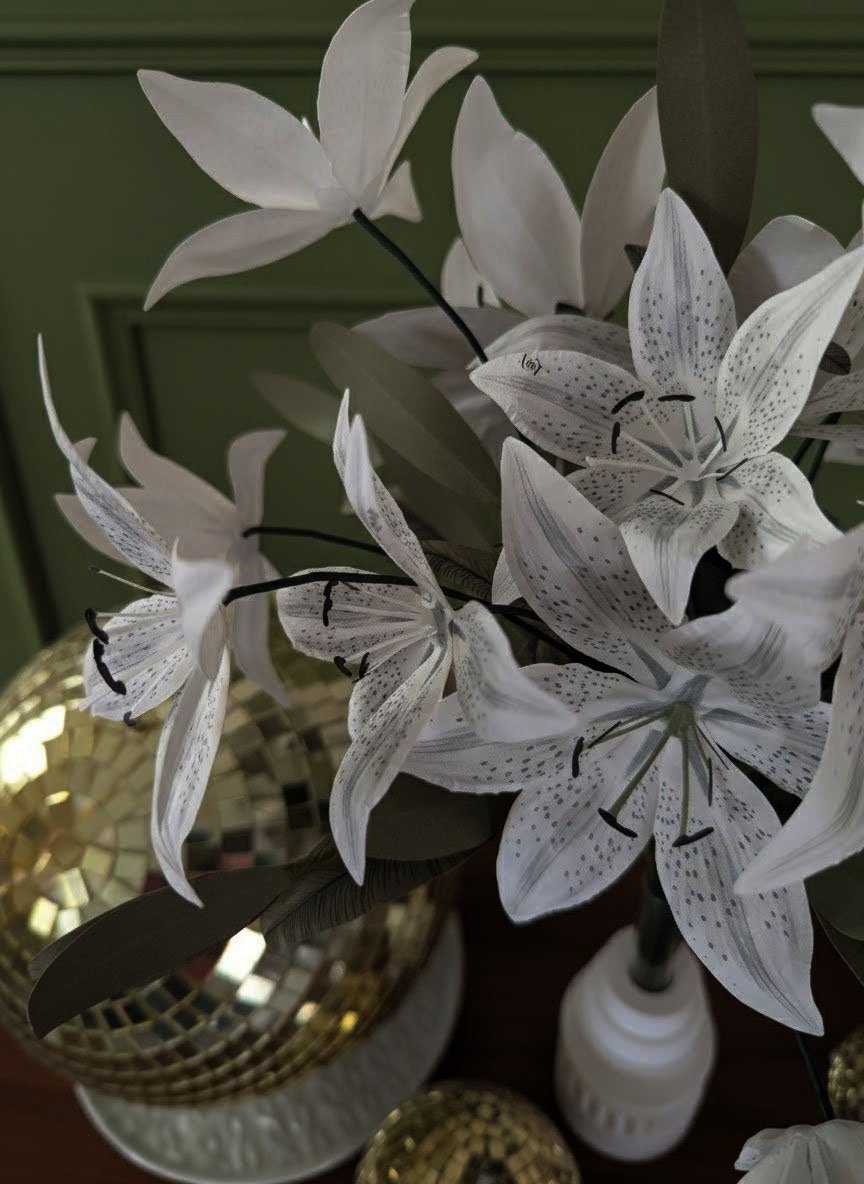 Vue de dessus (plongée) d'un bouquet de lys Stargazer en papier artisanal, montrant les motifs mouchetés et le cœur détaillé avec pistil vert.