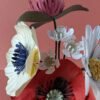 Bouquet de fleurs en papier artisanal de face, composé d'un coquelicot rouge, d'une anémone crème, d'une marguerite blanche et d'un trèfle bordeaux