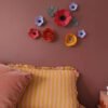 Détail de fleurs murales aimantées en papier avec effet relief sur mur coloré dans une chambre