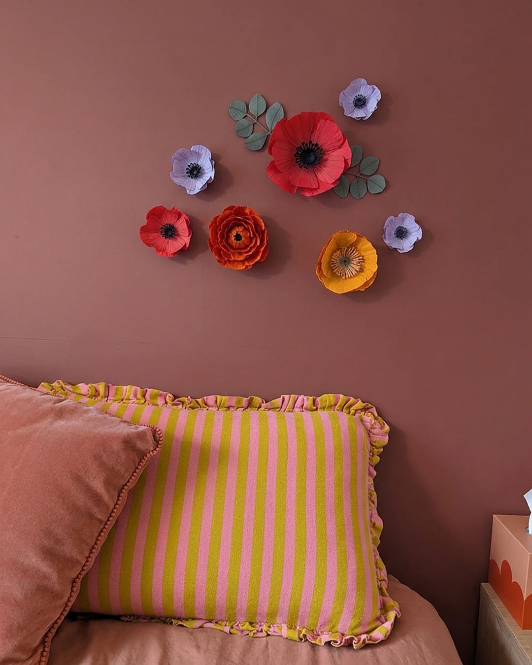 Détail de fleurs murales aimantées en papier avec effet relief sur mur coloré dans une chambre