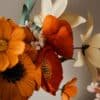 Détail d'un bouquet de fleurs en papier avec pavots orange brûlé, anémone jaune soleil et lys ivoire, création artisanale Anaïs LVDX