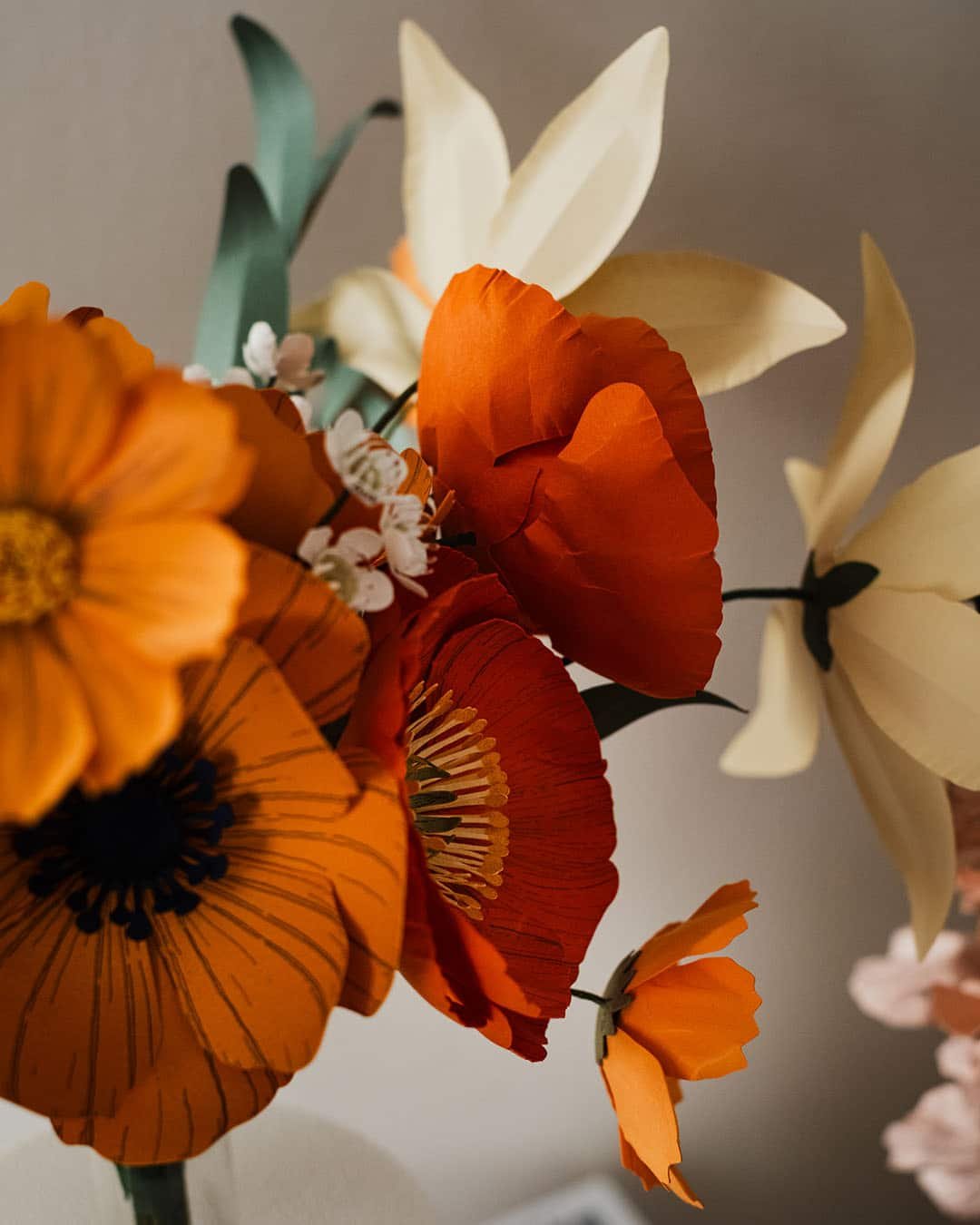 Détail d'un bouquet de fleurs en papier avec pavots orange brûlé, anémone jaune soleil et lys ivoire, création artisanale Anaïs LVDX