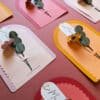 Vue d'atelier des cartes fleuries Merci Fleuri collection Éclore, trois coloris disposés en perspective
