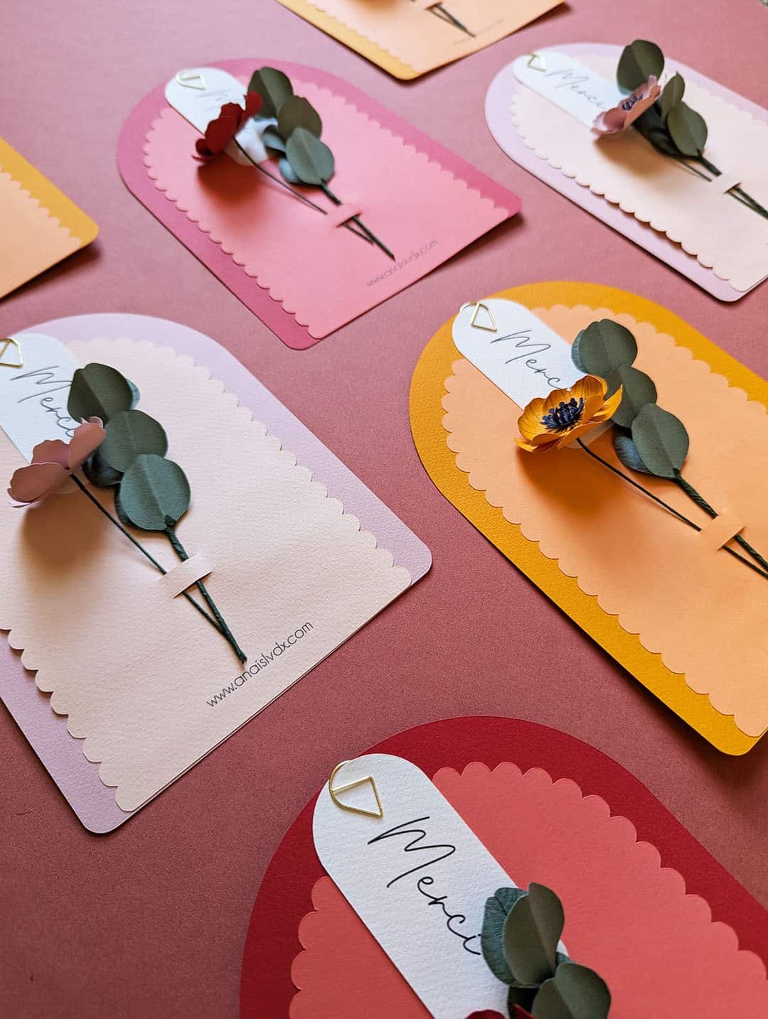 Vue d'atelier des cartes fleuries Merci Fleuri collection Éclore, trois coloris disposés en perspective
