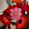 Gros plan sur un cosmos coloris hortensia en papier d'art teinté au centre du bouquet Masterpiece Rose, entouré d'anémones corail et pavots fuchsia, Anaïs LVDX