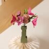 Bouquet de fleurs en papier avec tulipes fuchsia, hellébores viola et œillets rosa dans un vase graphique vert olive