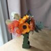 Vue d'ensemble du bouquet de fleurs en papier Théodore avec anémones, renoncules, leucospermums et fougères dans un vase vert