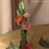Composition de fleurs en papier avec branche de hêtre, oeillet rose pâle et têtes d'épingles orange et rose