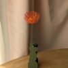 Tige unique de tête d'épingles orange en papier dans un vase vert olive La Chambre d'Ami