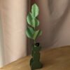 Branche de hêtre en papier coloris vert pomme dans un vase vert imprimé en 3D sur une table en bois