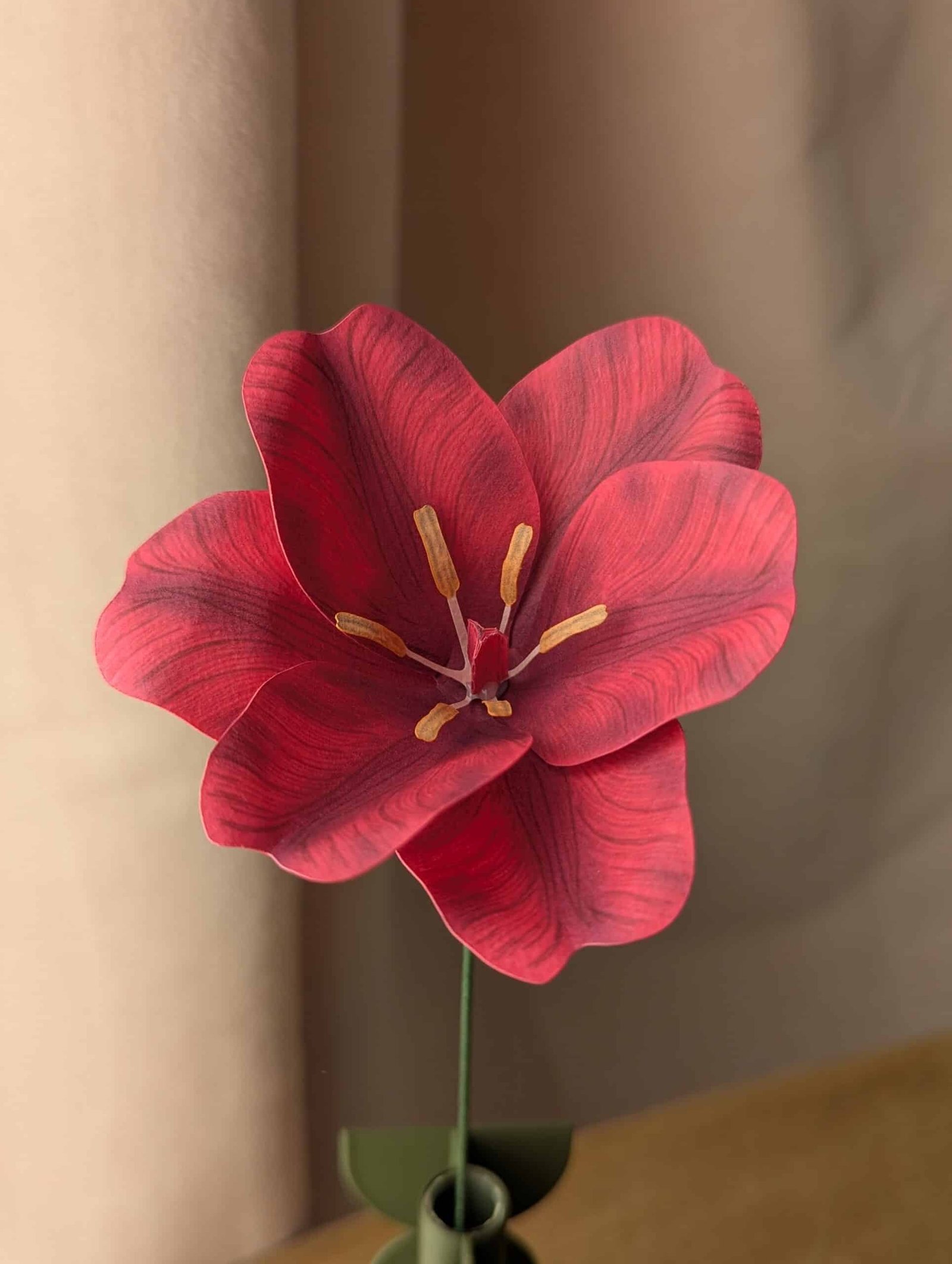 Gros plan sur une tulipe ouverte en papier fuchsia avec ses étamines jaunes